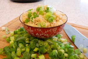 a bowl of Filipino Garlic Fried RIce with green onions