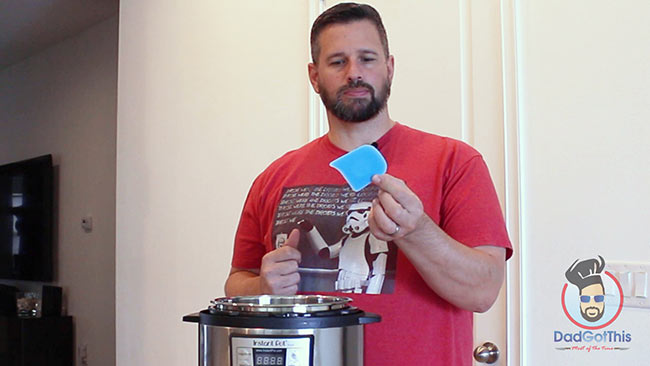 Dad holding a silicone pan scraper.