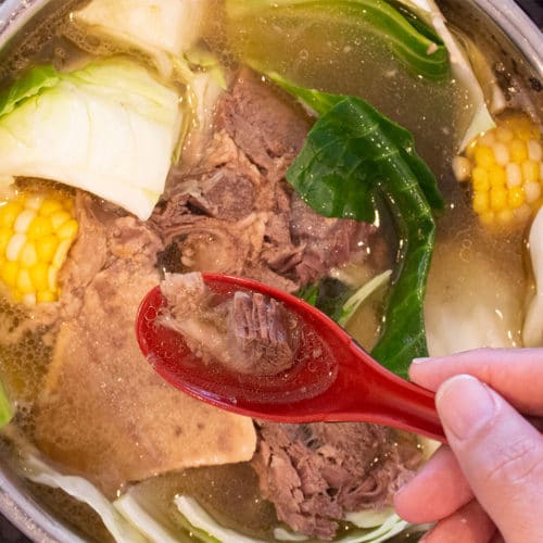 Beef Bulalo Soup in an Instant Pot with a red soup spoon