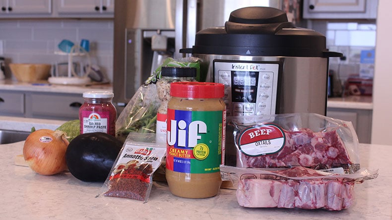 an instant pot with kare kare ingredients in front