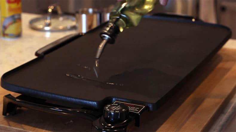 oil being poured on an electric griddle