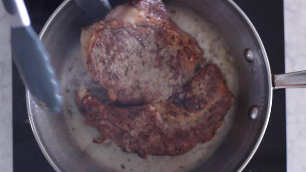 A steak being reverse seared in a pan