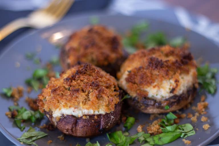 3 crab stuffed mushrooms on a grey plate