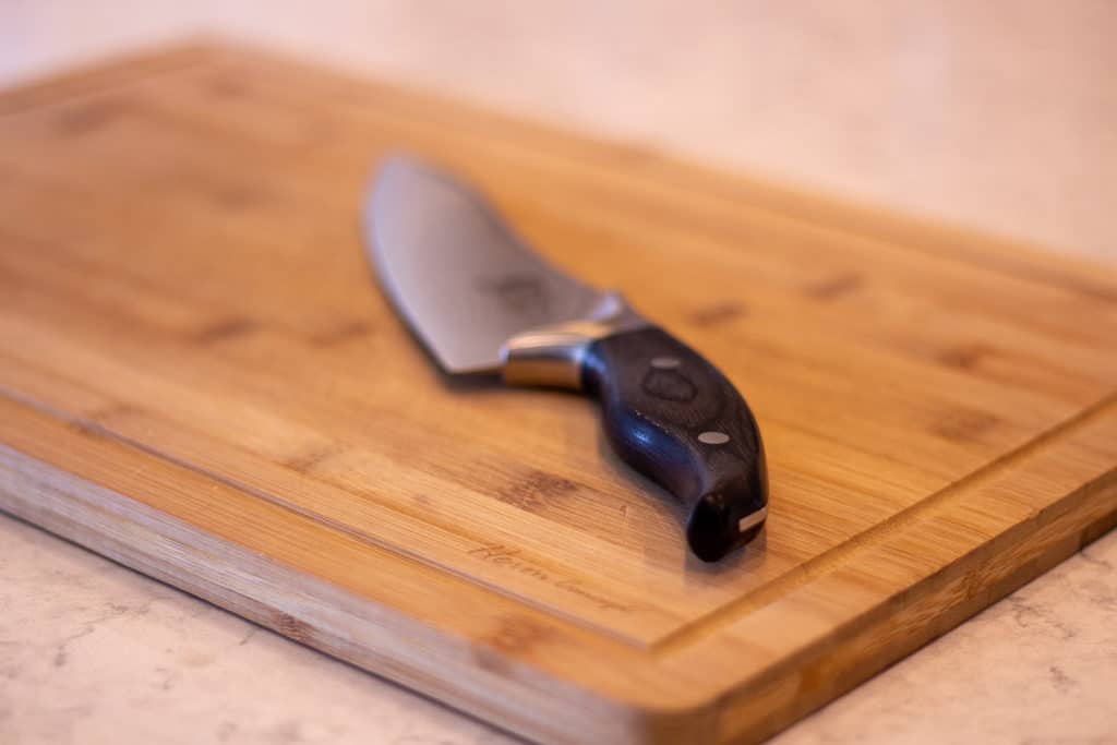 Bamboo Cutting Board with a Knife on it