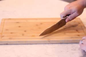 knife cutting on a wood cutting board