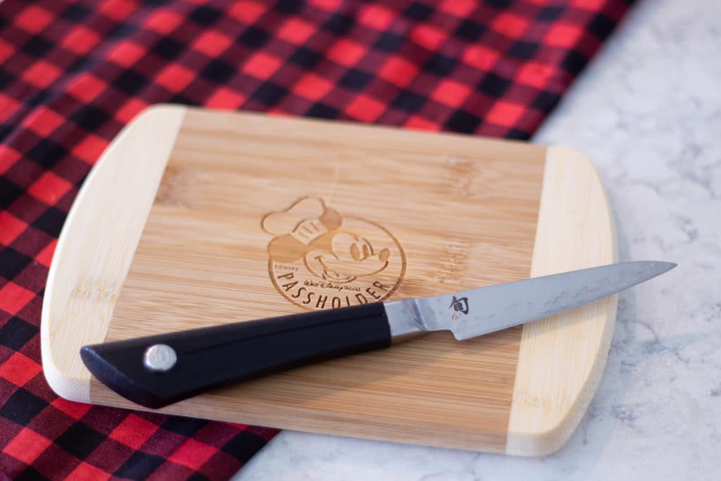 a small cutting board with mickey logo and a knife