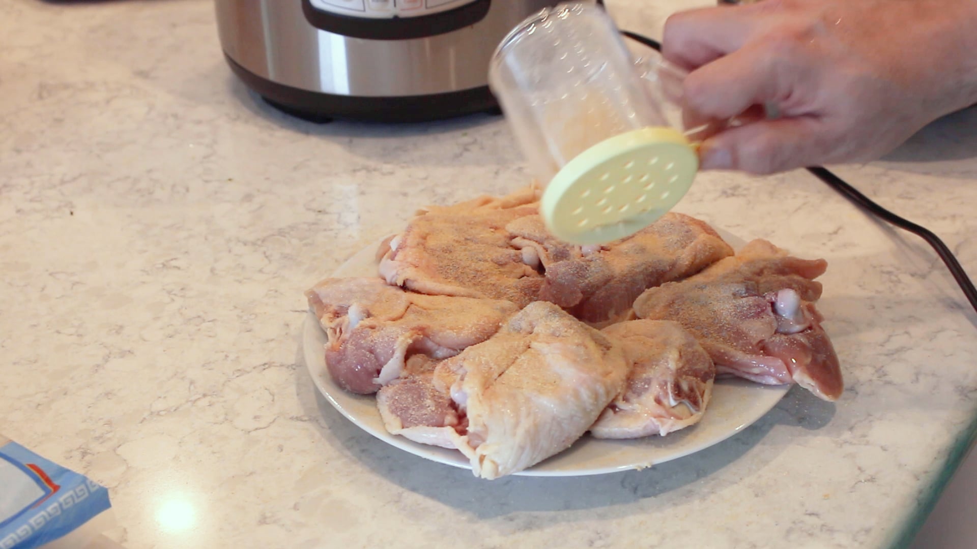 chicken thighs being seasoned for pancit