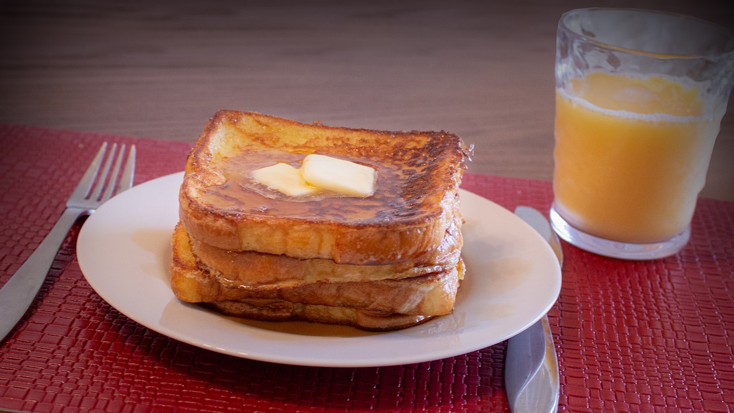 Frech toast on a plate with a glass of orange juice