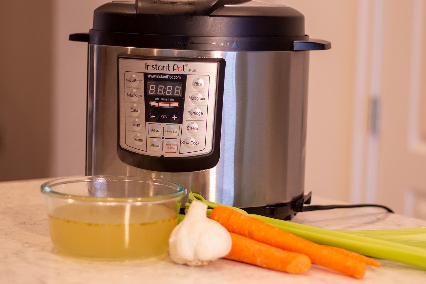 Chicken stock in a bowl in front of an instant pot