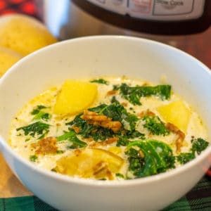 a bowl of zuppa toscana in front of an instant pot