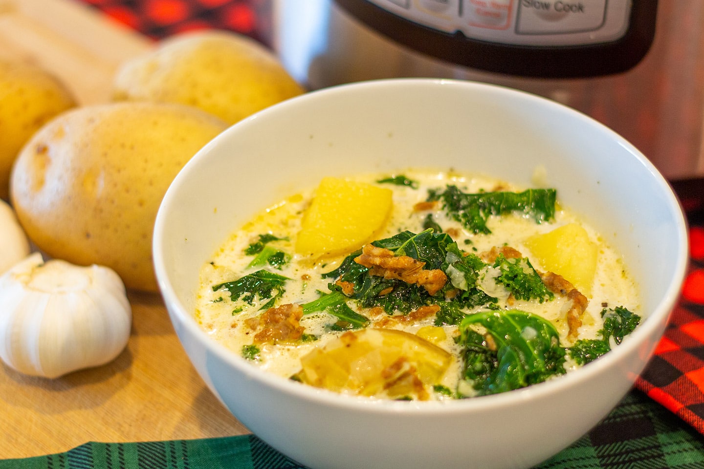 a bowl of zuppa toscana in front of an instant pot