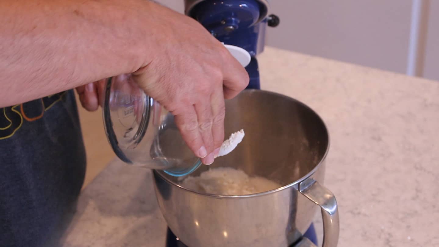 adding ingredients to a stand mixer