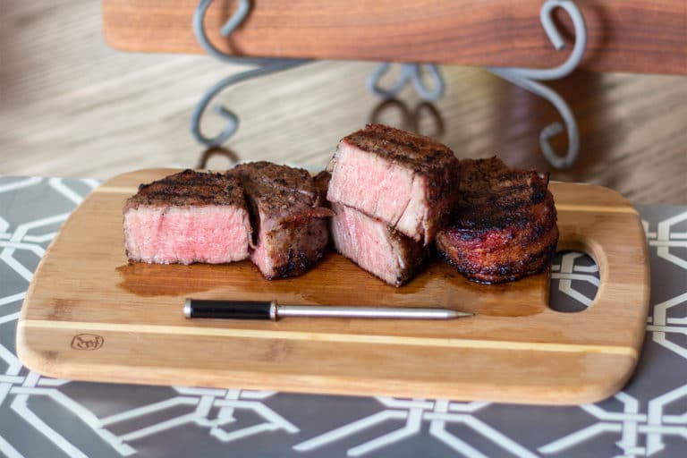 bacon wrapped filets on a cutting board