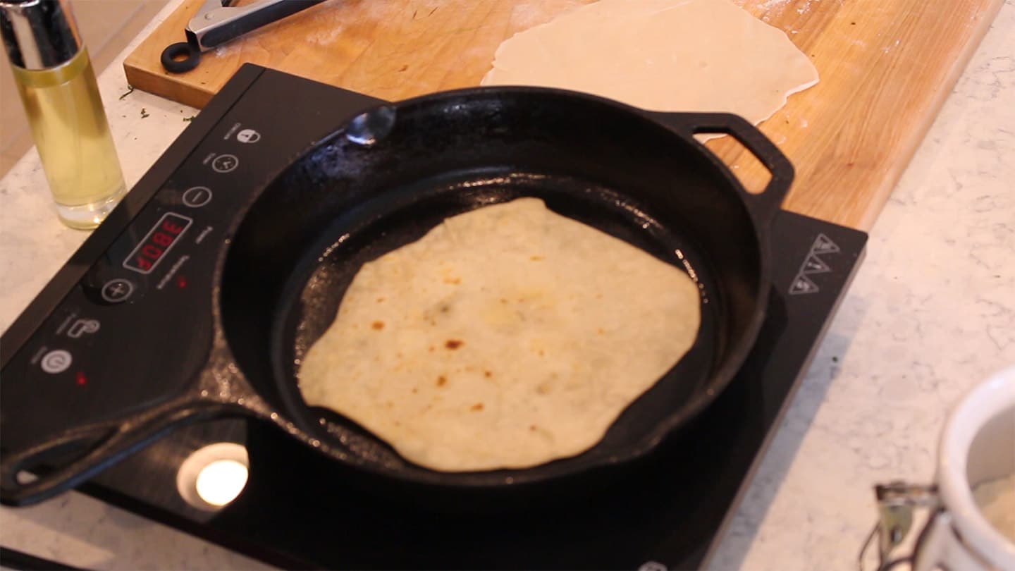 cooking tortillas in a cast iron pan