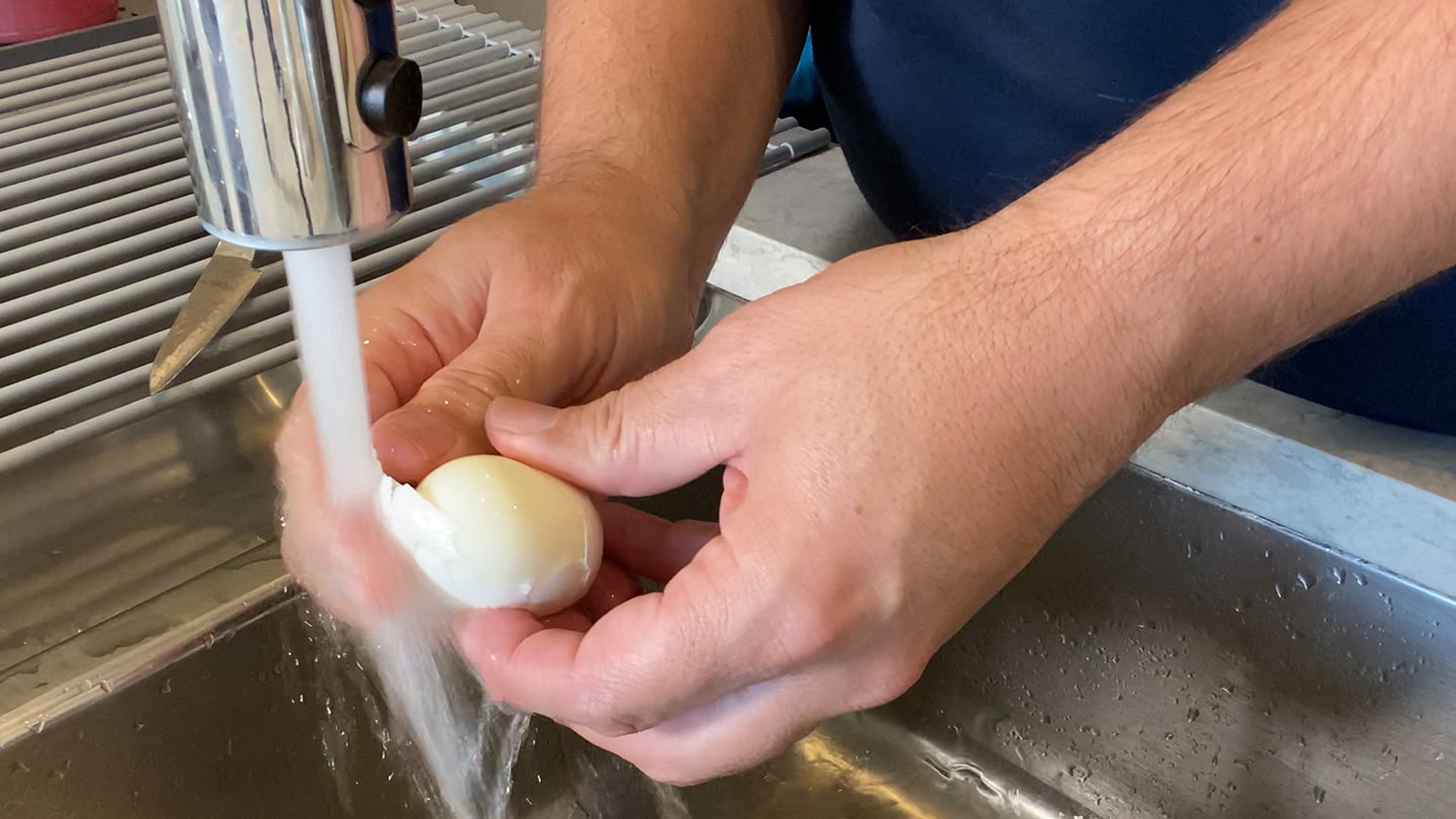peeling eggs under running water