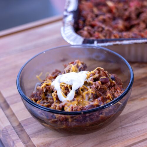 Ninja Woodfire Over the Top Chili topped with shredded cheddar cheese and sour cream