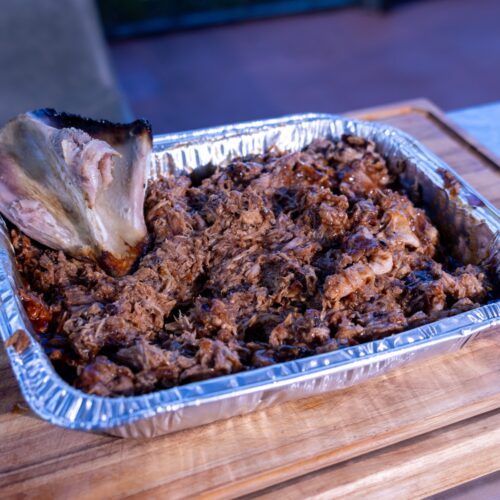 Ninja Woodfire Pulled Pork with bark and the removed bone in a foil pan